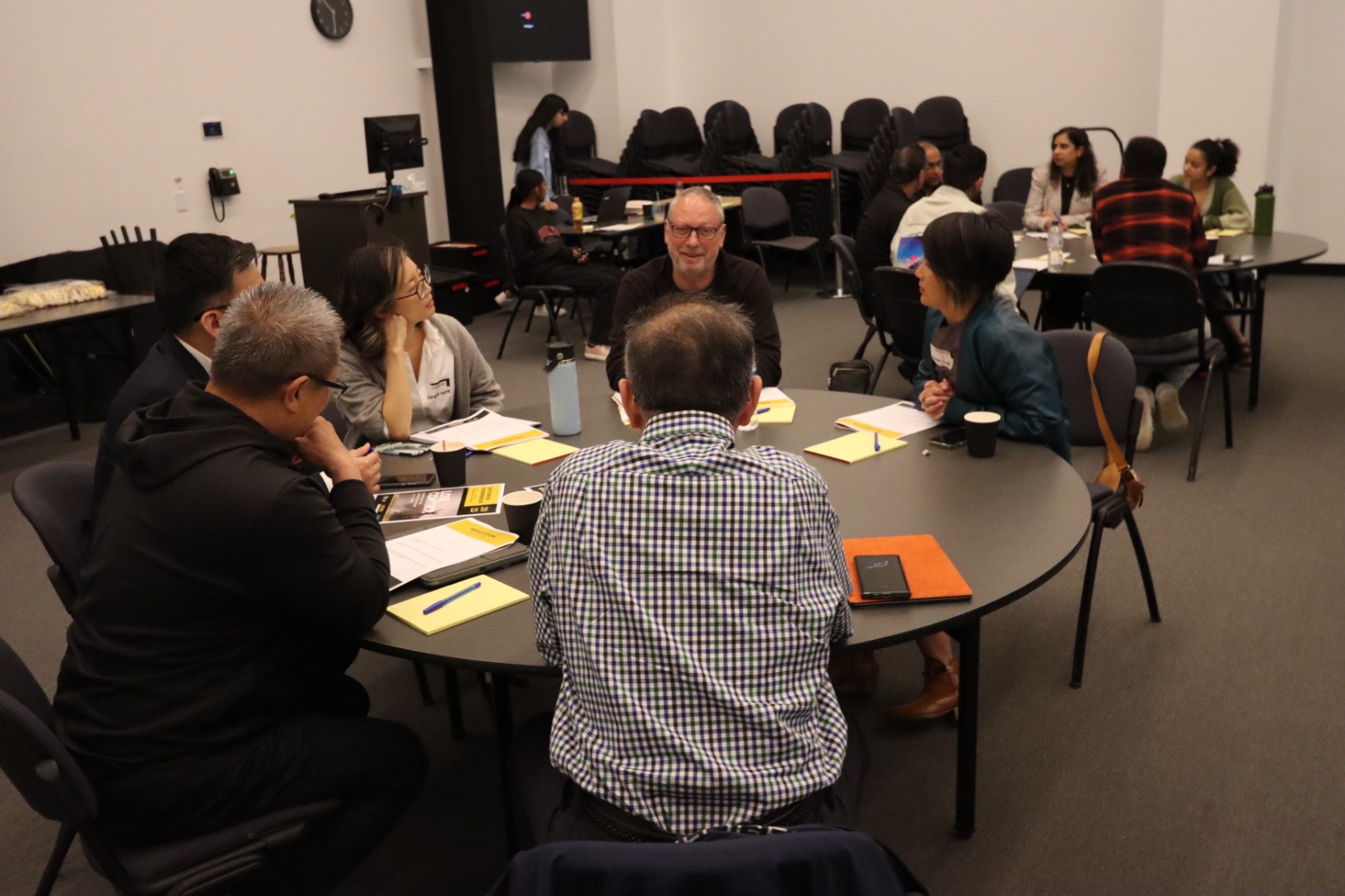 Small-group discussion with notes and refreshments around a table